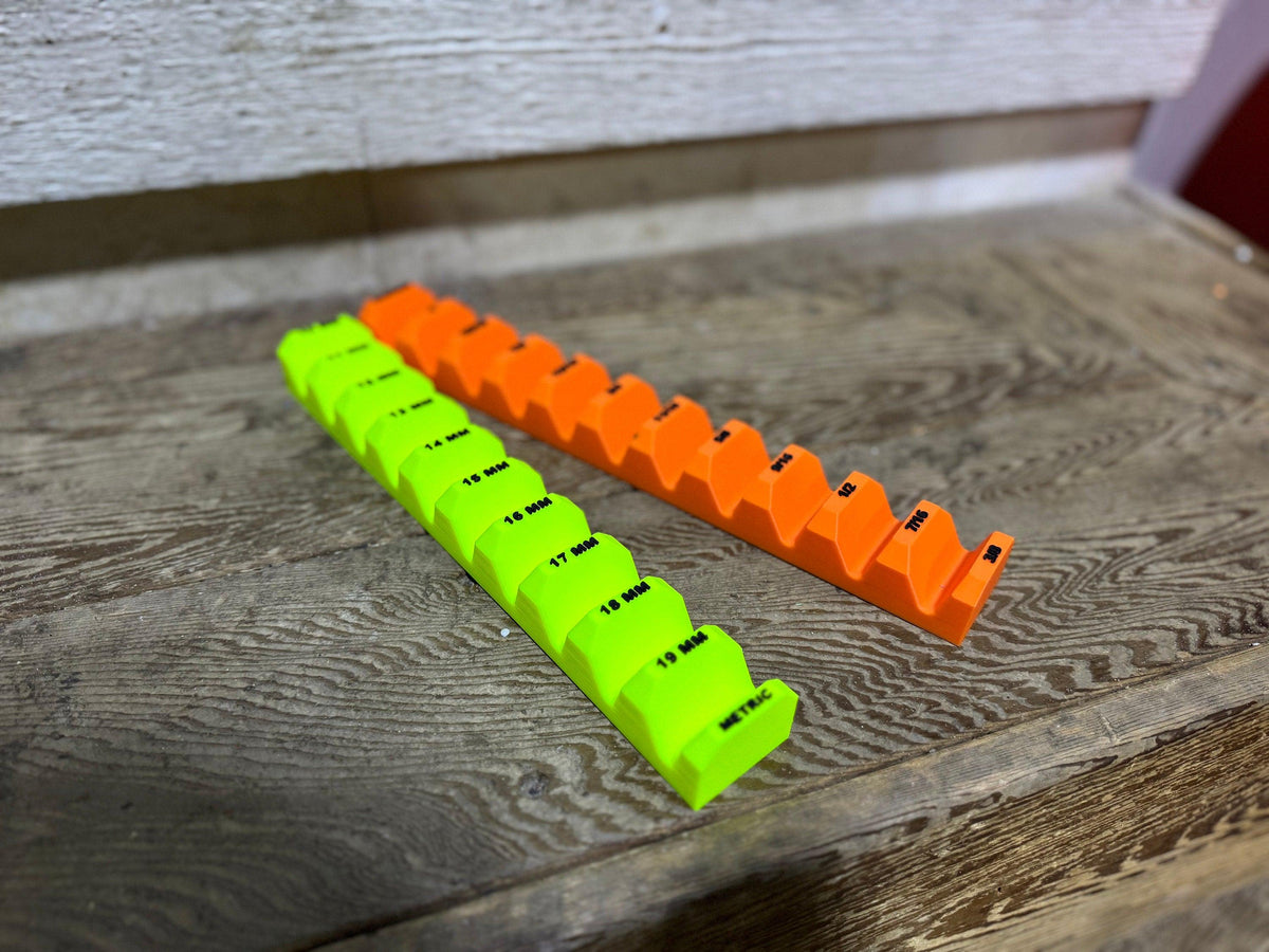 Empty neon yellow and orange wrench holders on a wood surface, showing the labeled slots and raised dividers.