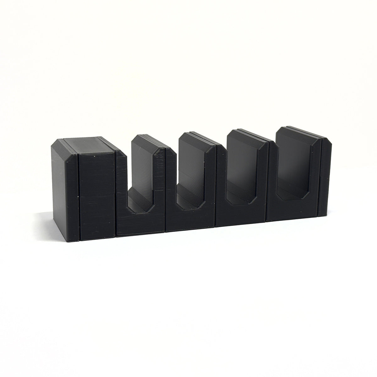 Angled view of connected black pliers holders showing the deep tool slots.