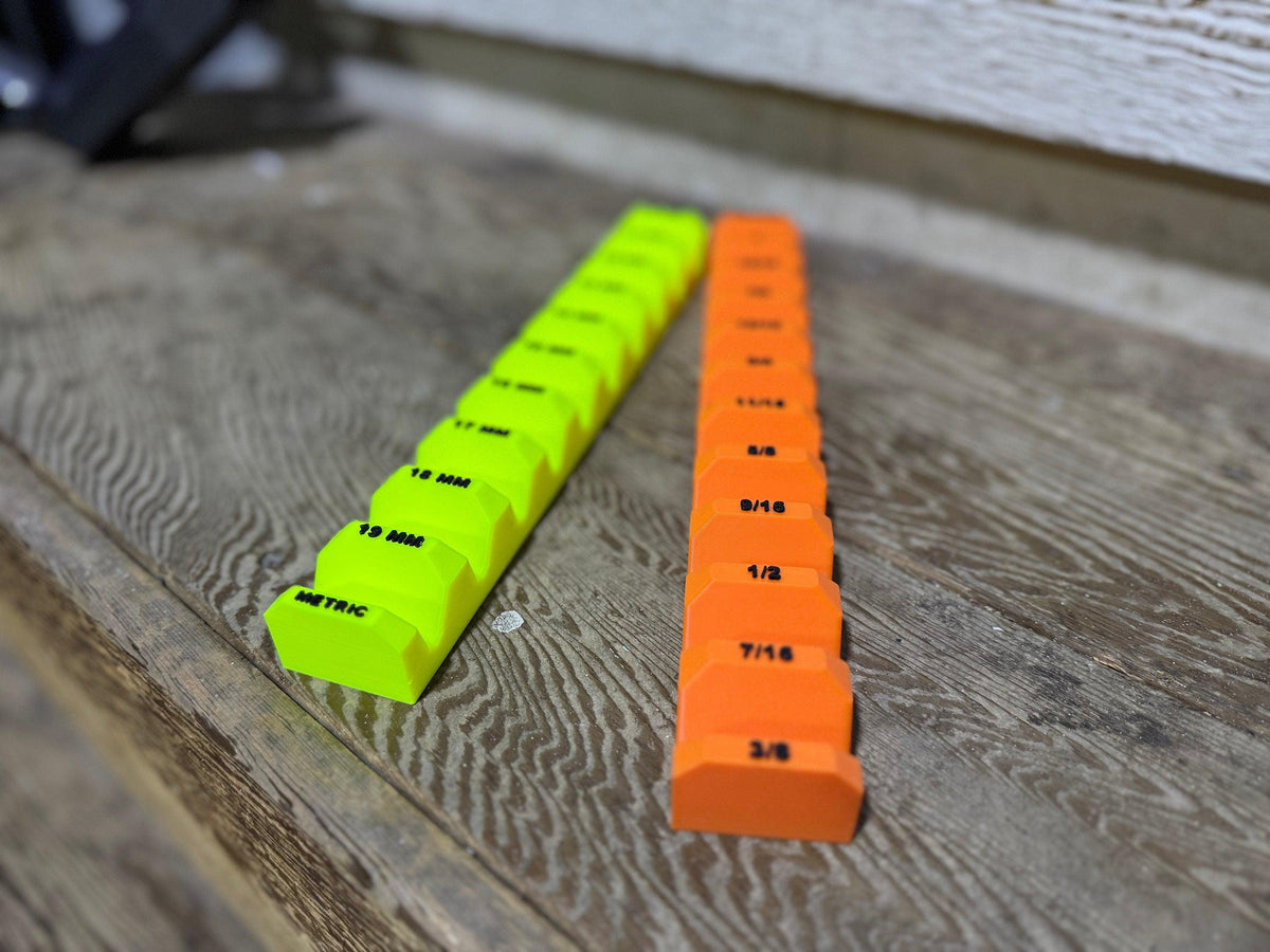 Low angled view of empty neon yellow and orange wrench holders with size labels along the tops.