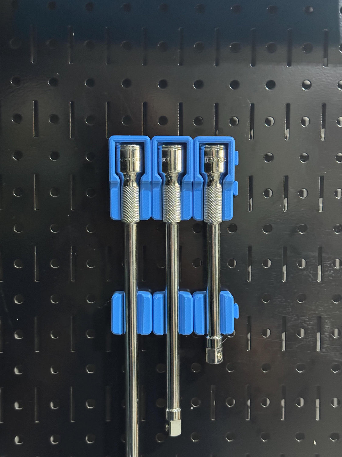 Wide view of three extensions held vertically by two rows of blue support pieces.