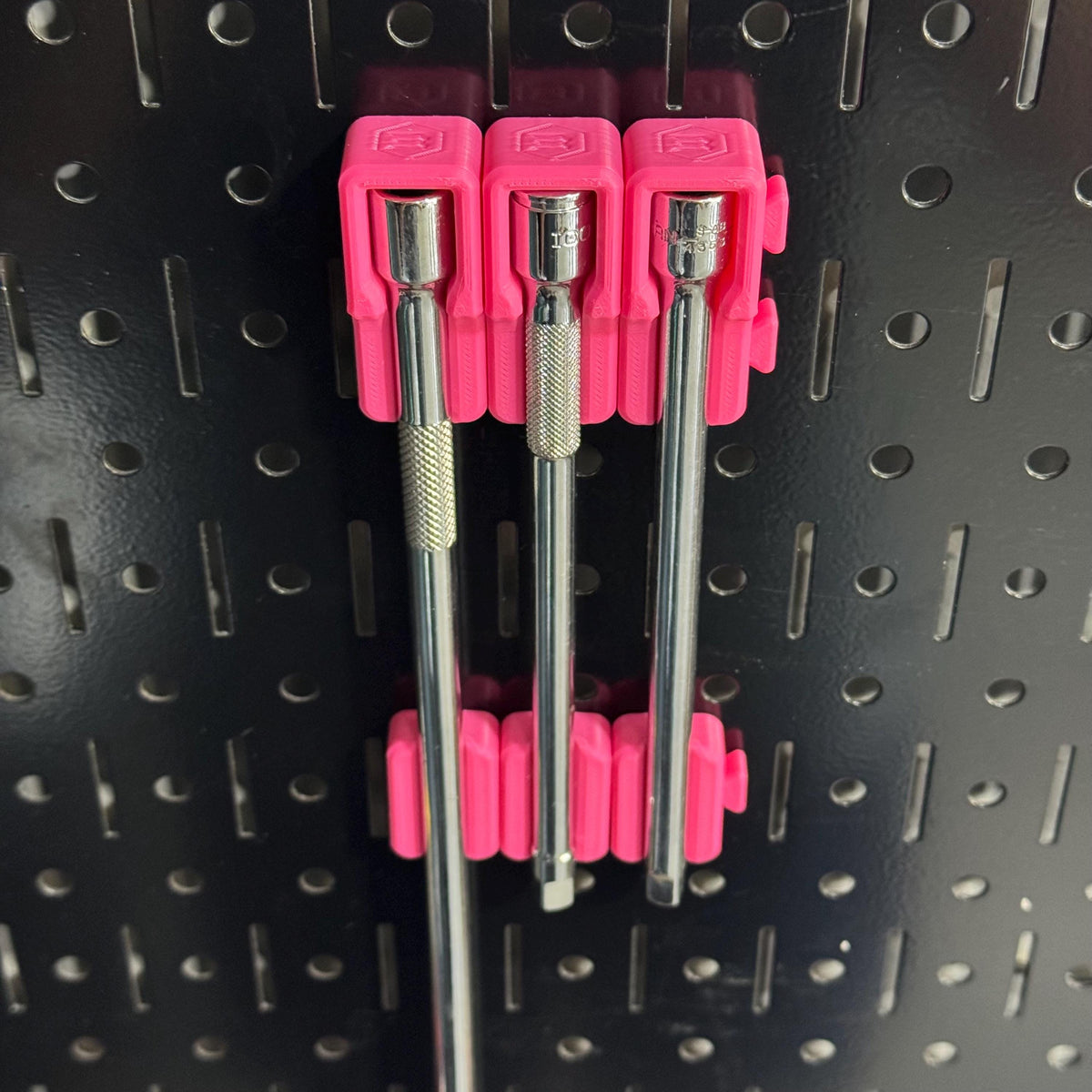 Angled close-up of three extension bars in matching pink upper holders and lower supports.