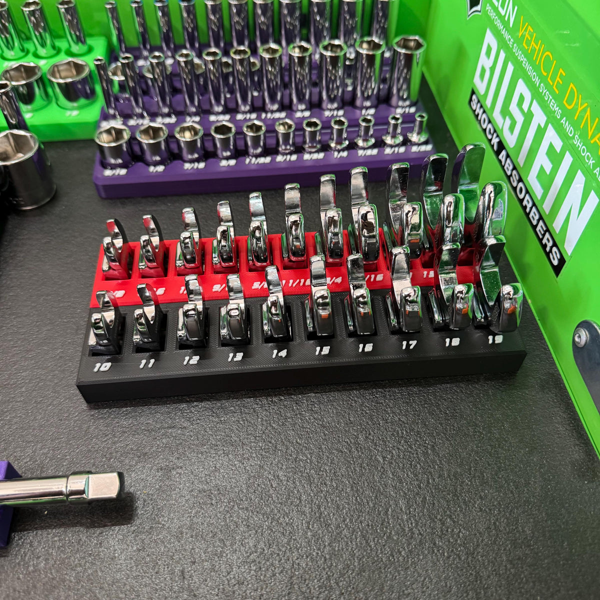 Red and black crowfoot wrench holders arranged side by side, with metric size labels visible on the black holder.