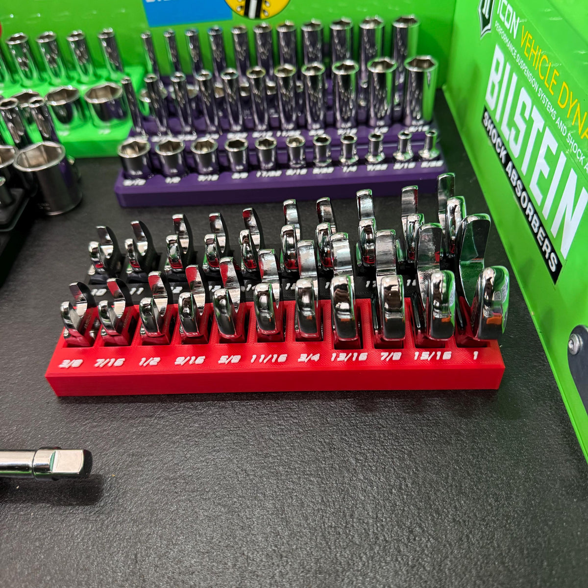 Front view of crowfoot wrenches in a red fractional-size holder, with a second row behind.