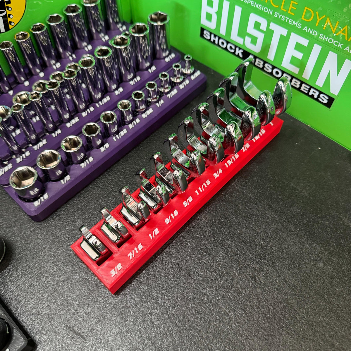 Overhead angled view of crowfoot wrenches arranged from small to large in a red holder.