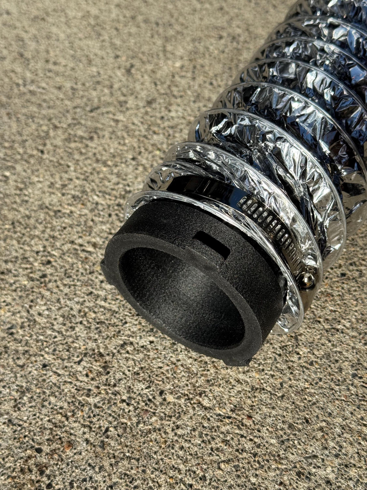 Black quick-connect fitting clamped to the end of a silver heater duct.